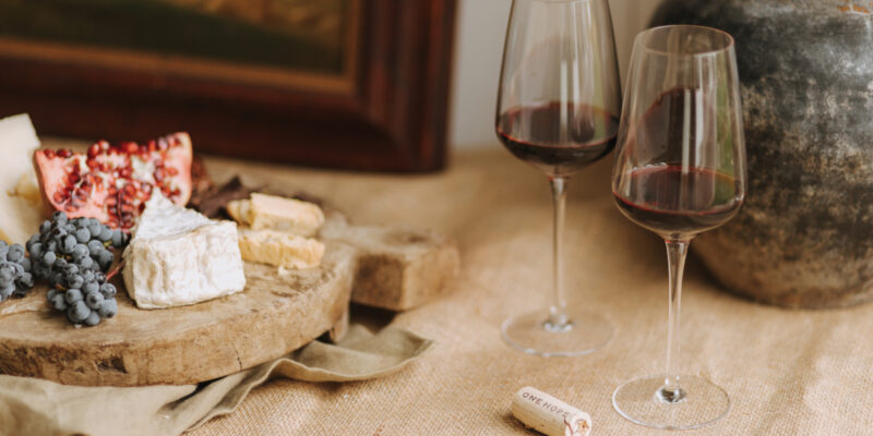 Romantic Valentine’s Day dinner setup with wine, cheese, and a cozy ambiance featuring cabernet sauvignon.